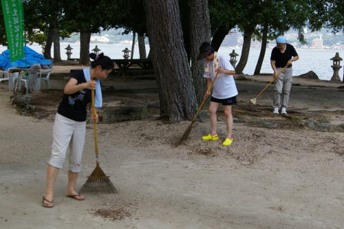 砂浜をホウキで掃いています